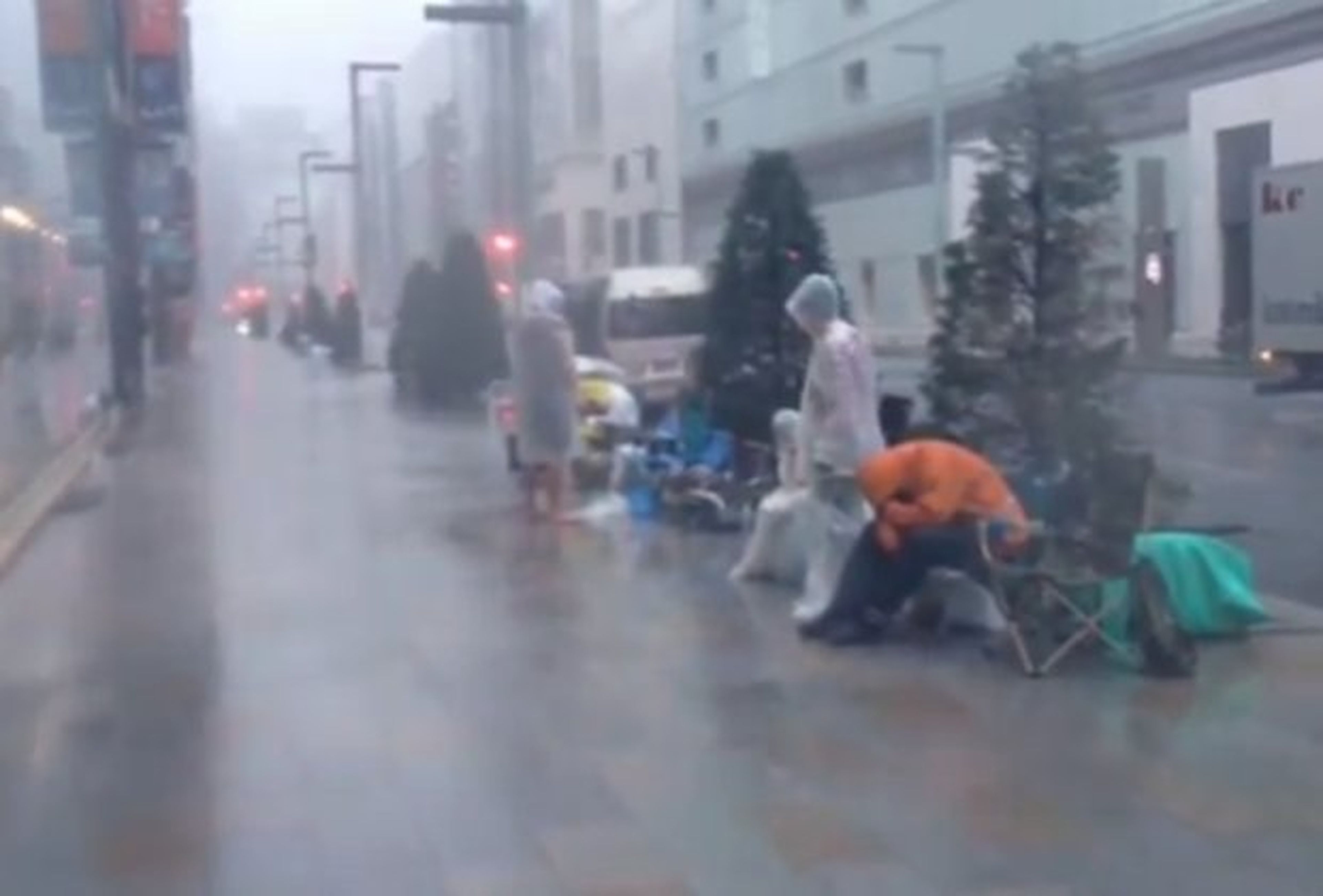 Fans de Apple siguen en fila en medio de un tifón