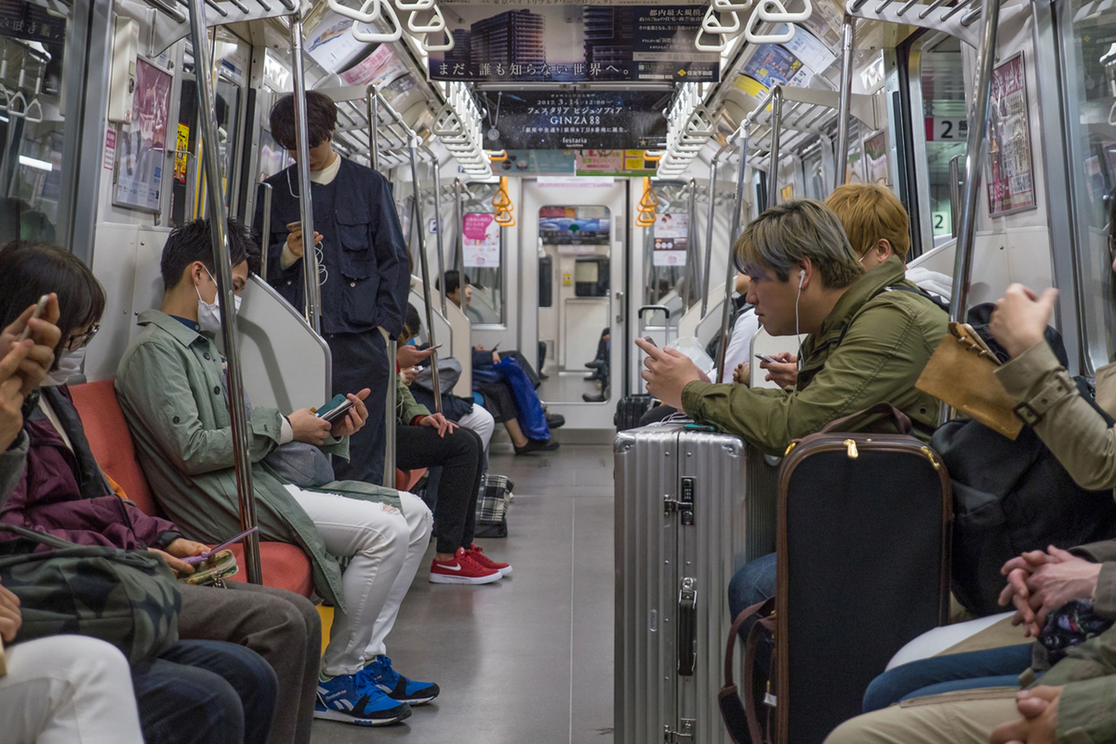 Gente usando el móvil en el metro