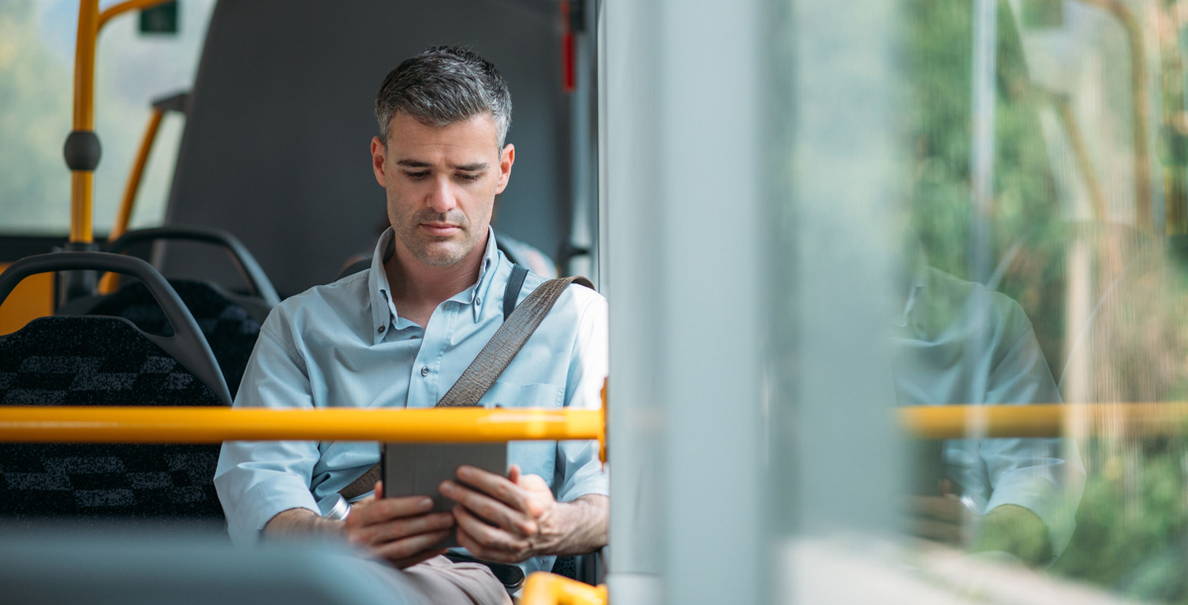Hombre usando tablet en un autobús