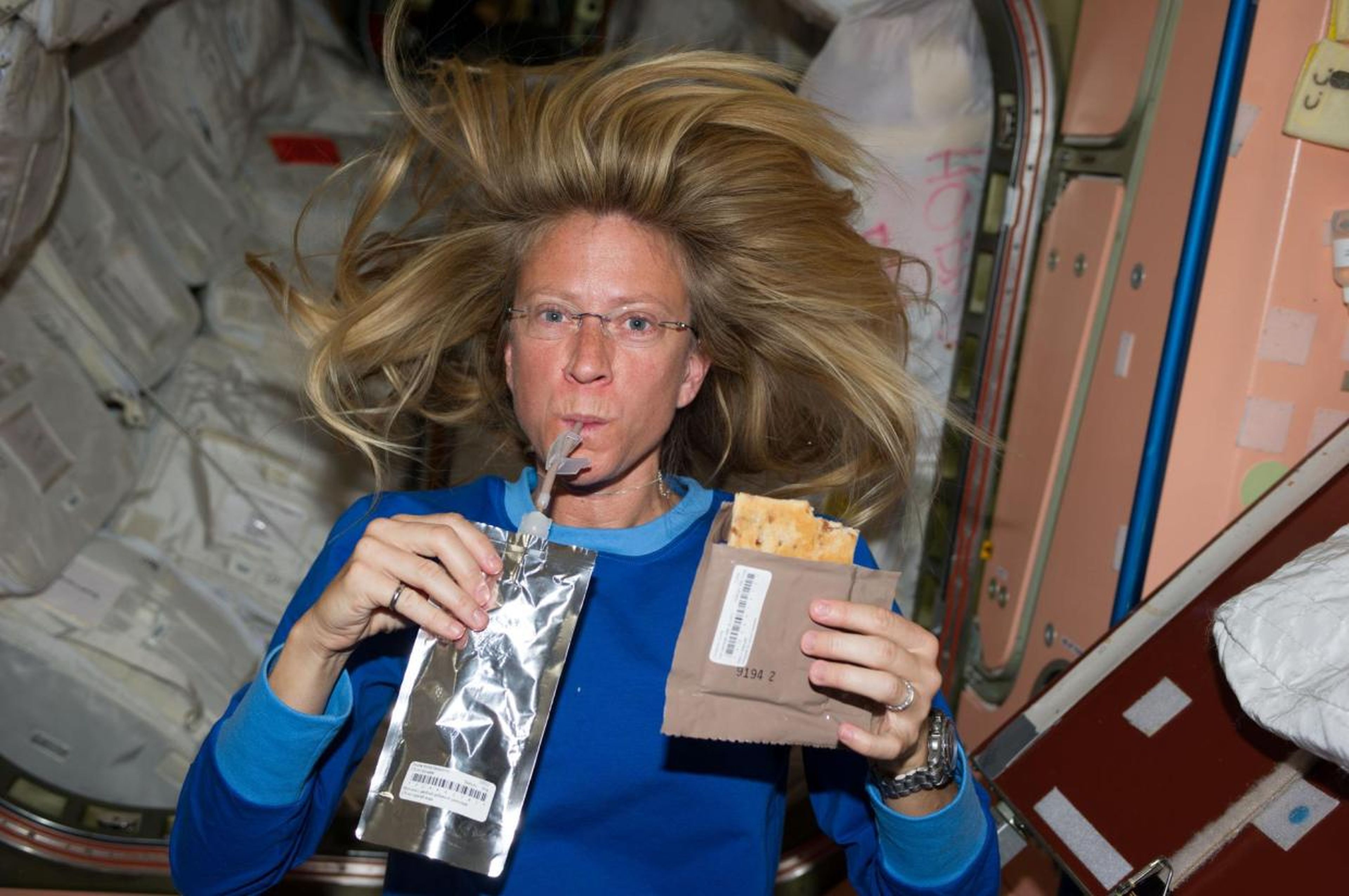 Astronauta Karen Nyberg de la NASA comiendo en la Estación Espacial Internacional