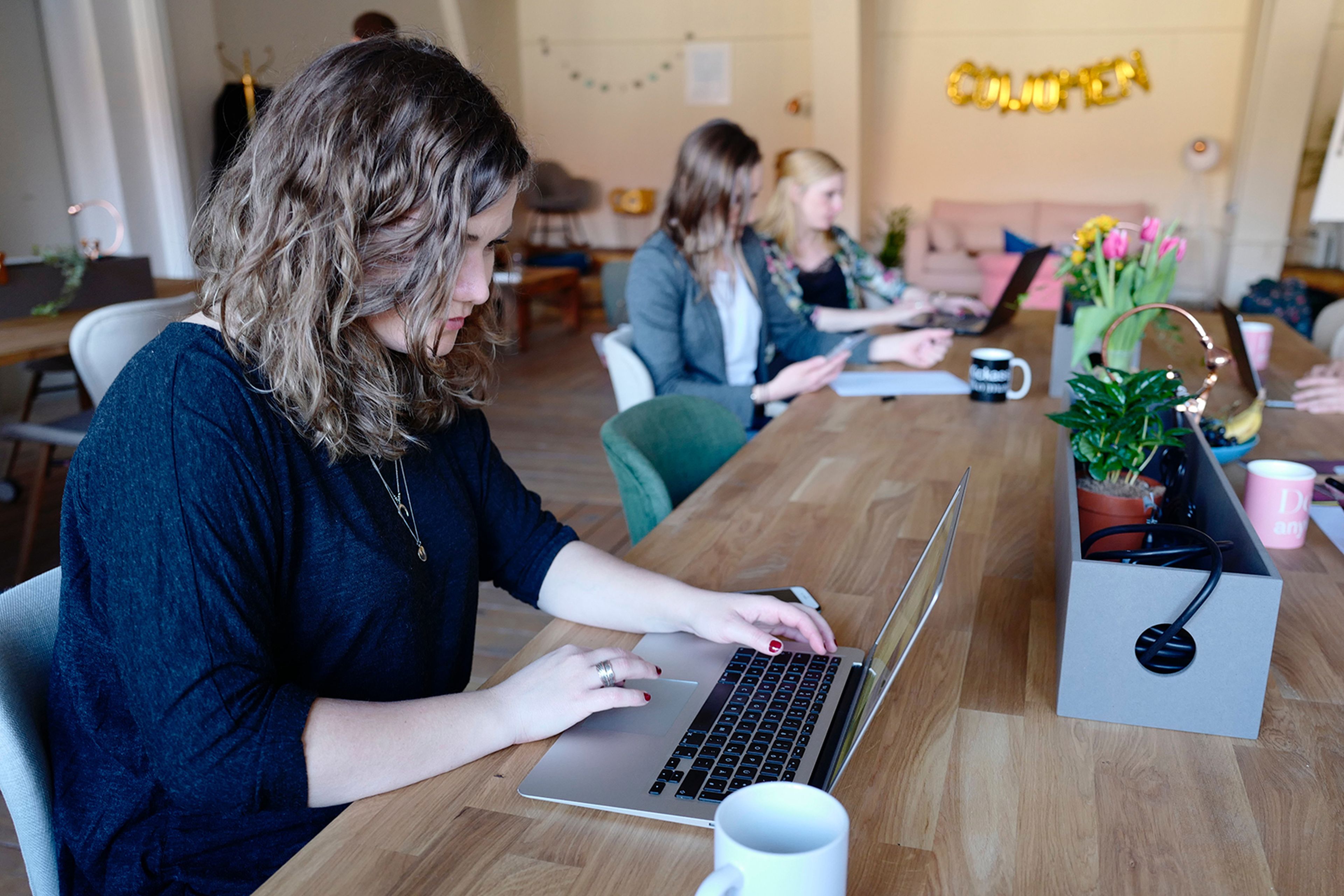 Una mujer usando un portátil en un coworking