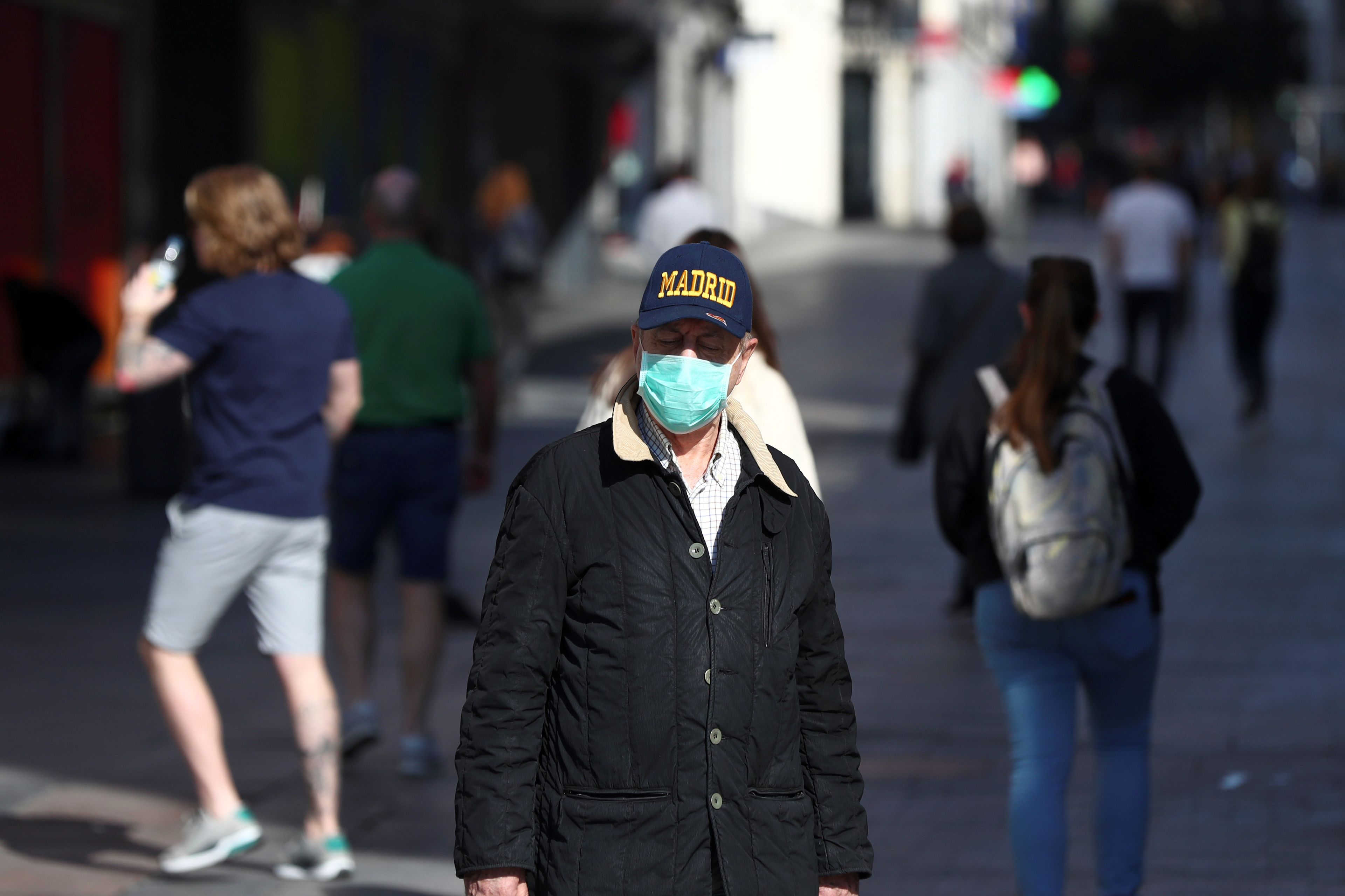 Un hombre camina por Madrid con mascarilla por temor la coronavirus