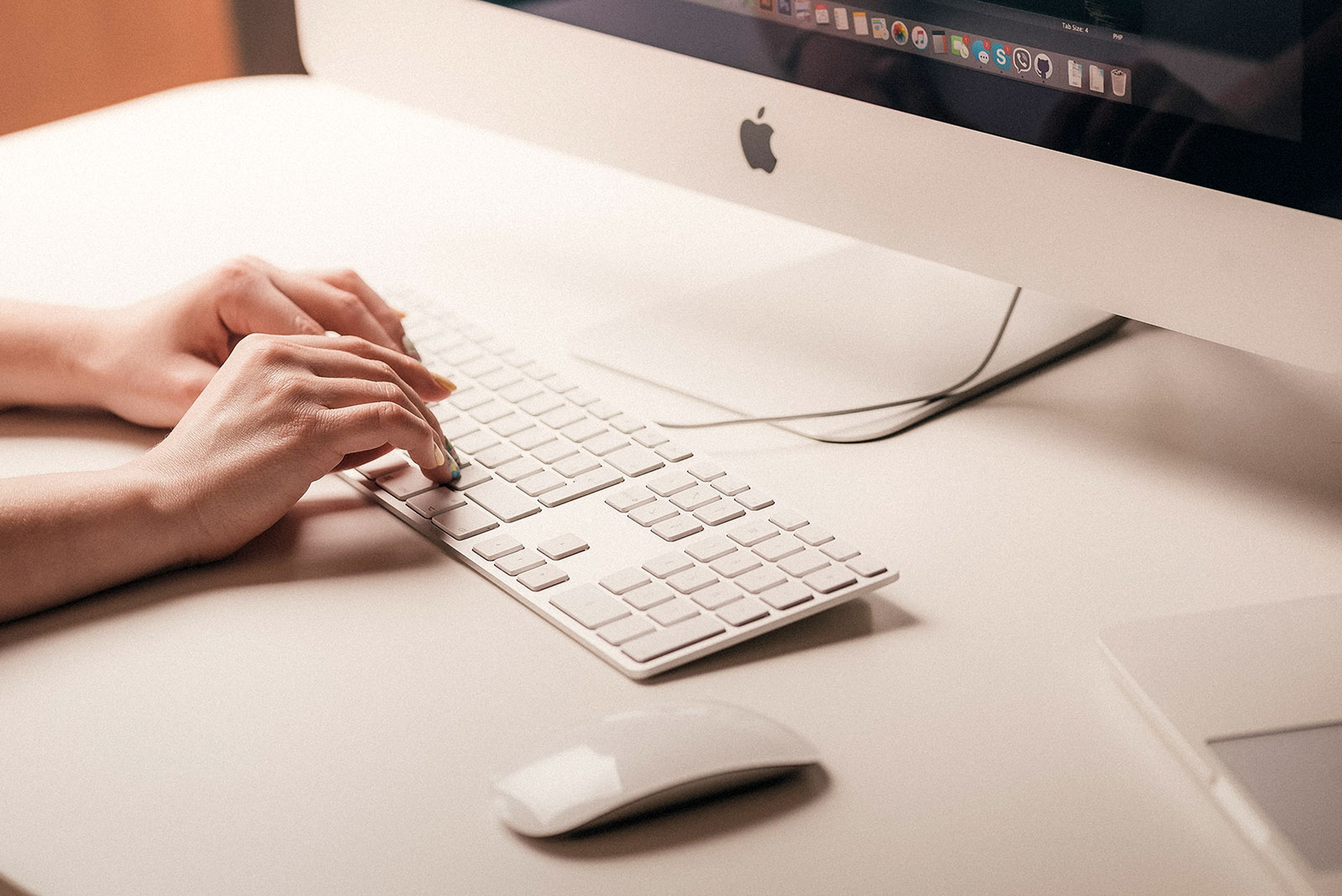 Mujer escribiendo en un teclado de Apple