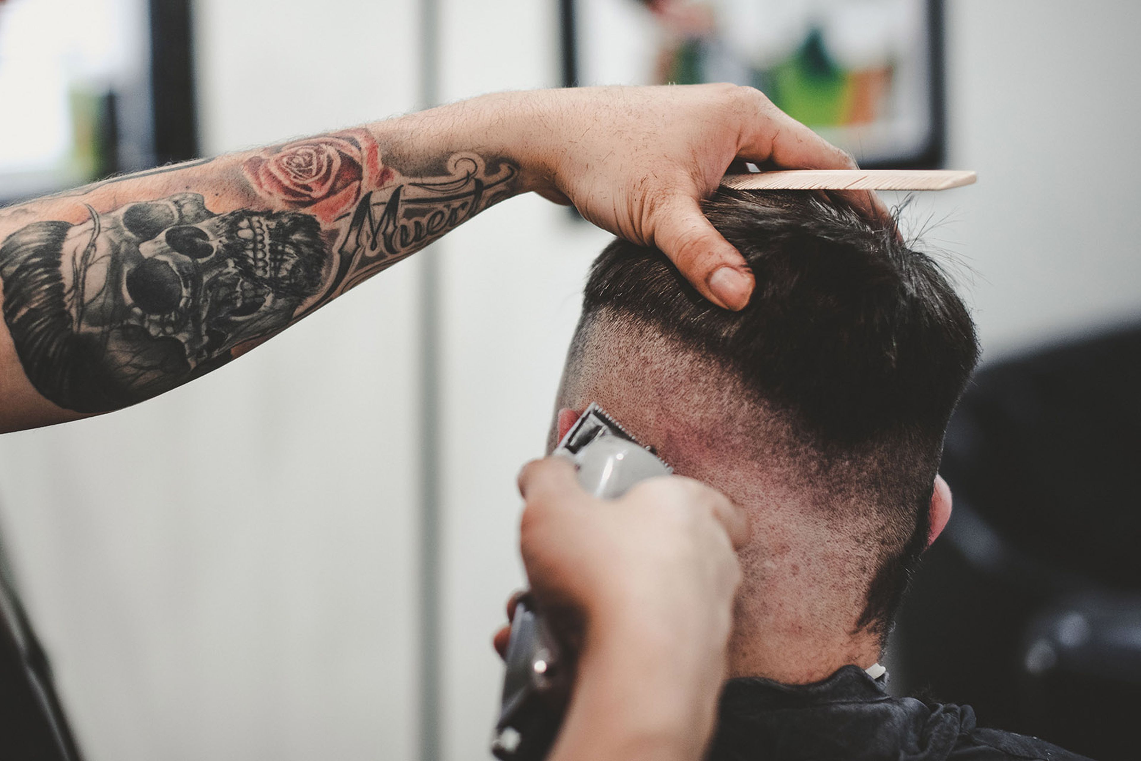 Barbero cortando el pelo con un cortapelos