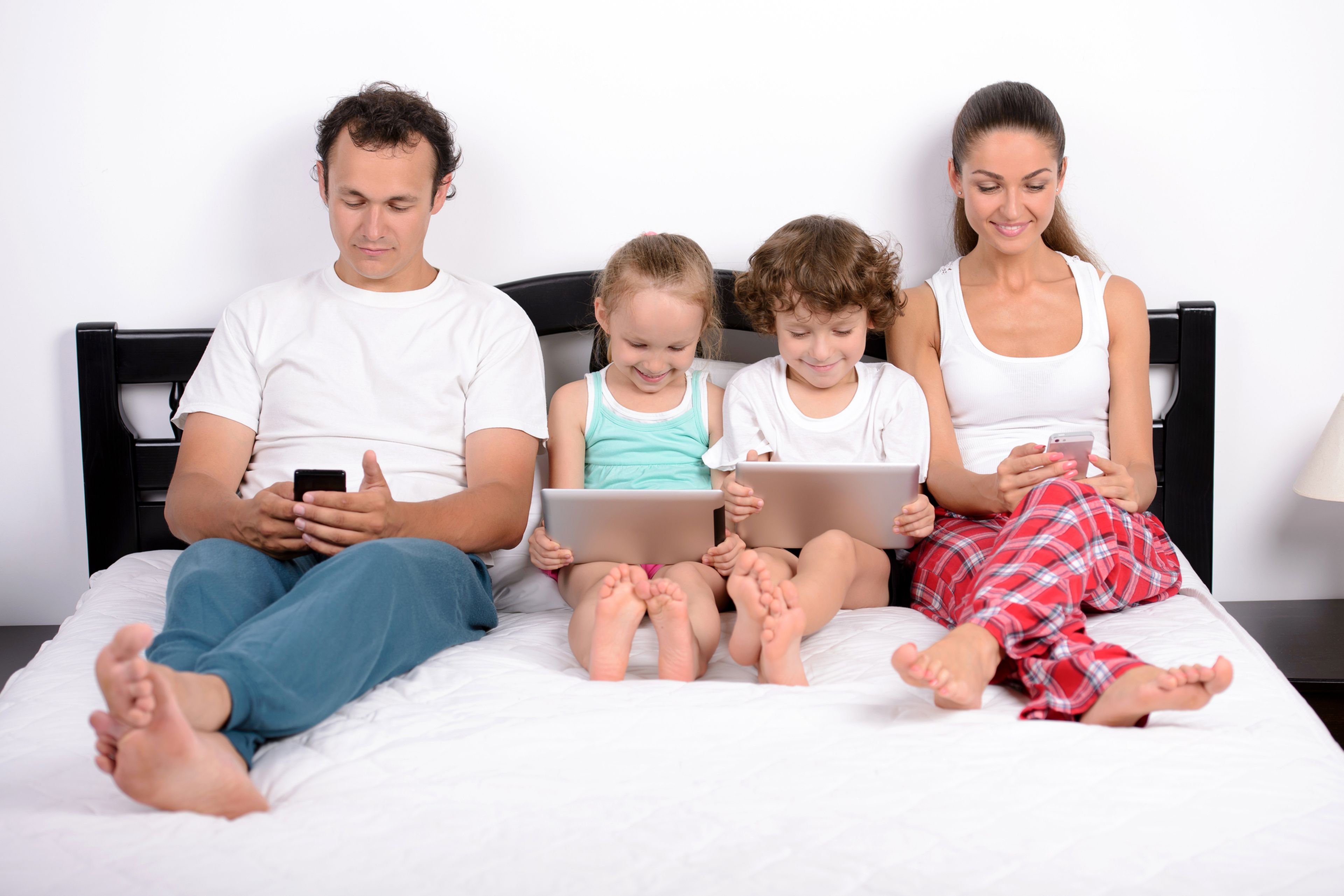 Familia con el móvil en la cama