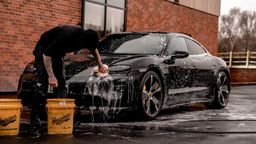 Hombre limpiando su coche a mano