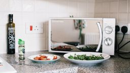Microondas con platos preparados en una cocina