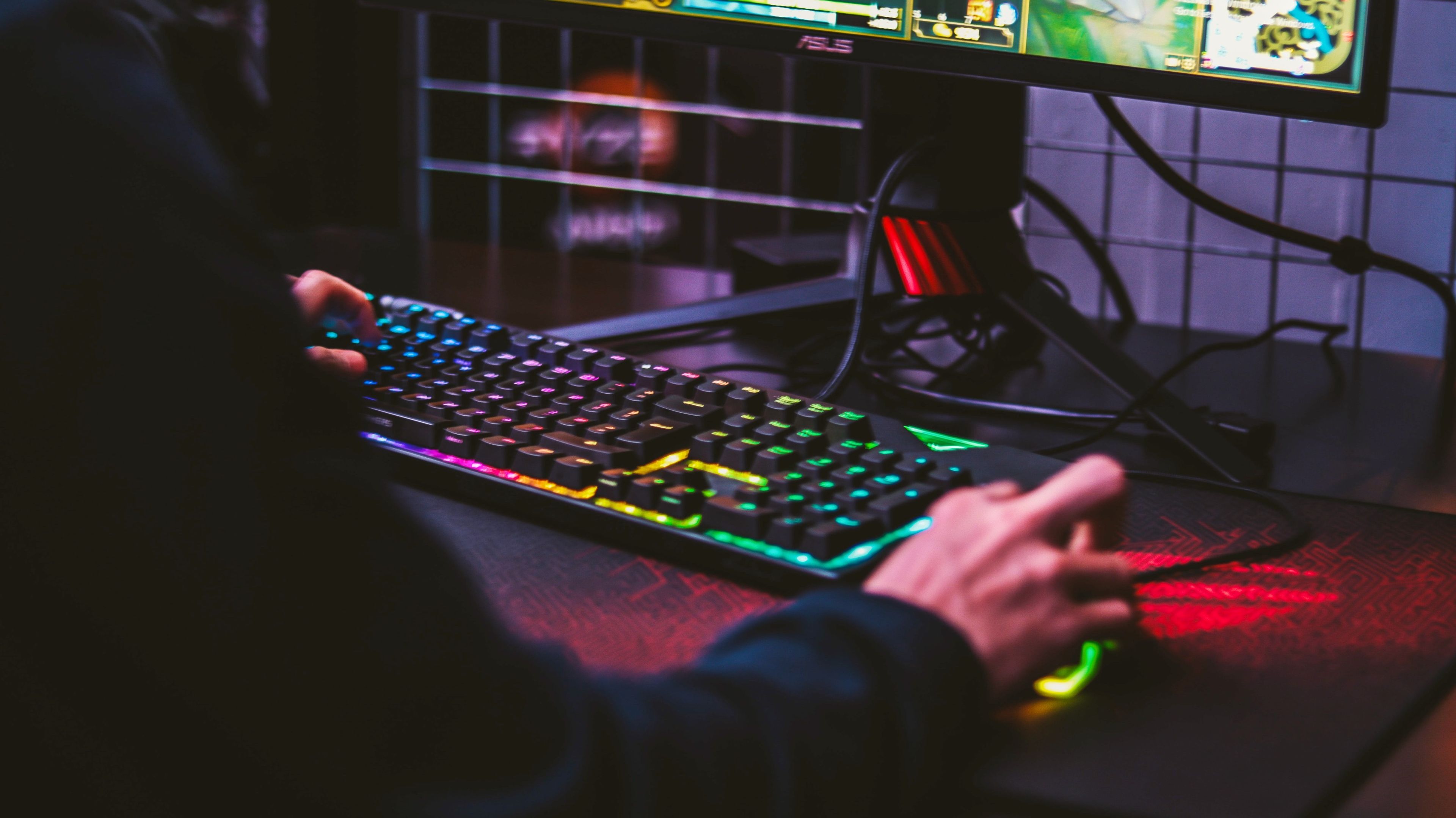 Persona jugando en un PC gaming con teclado y ratón RGB