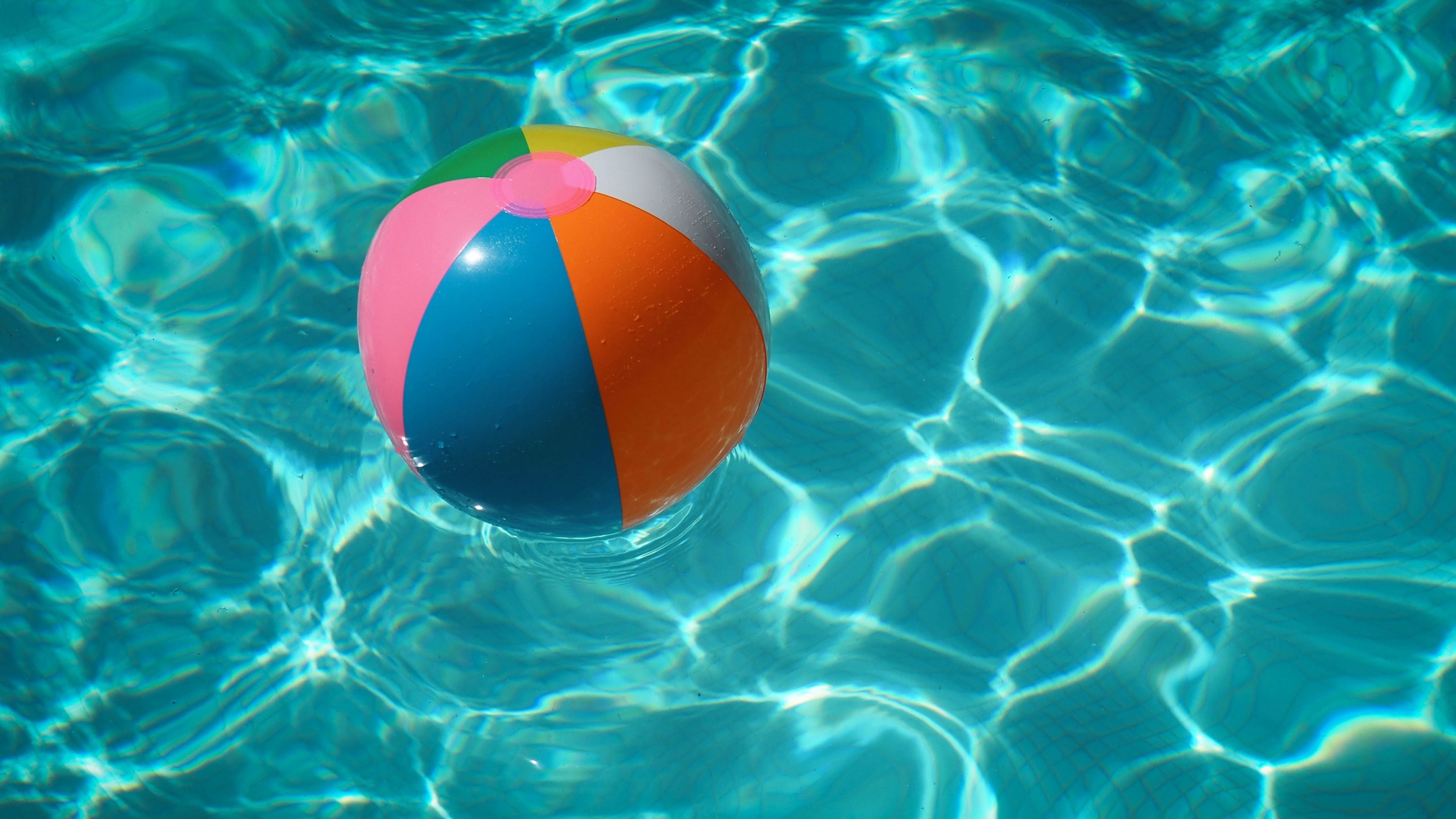 Pelota de playa en una piscina, estampa de verano