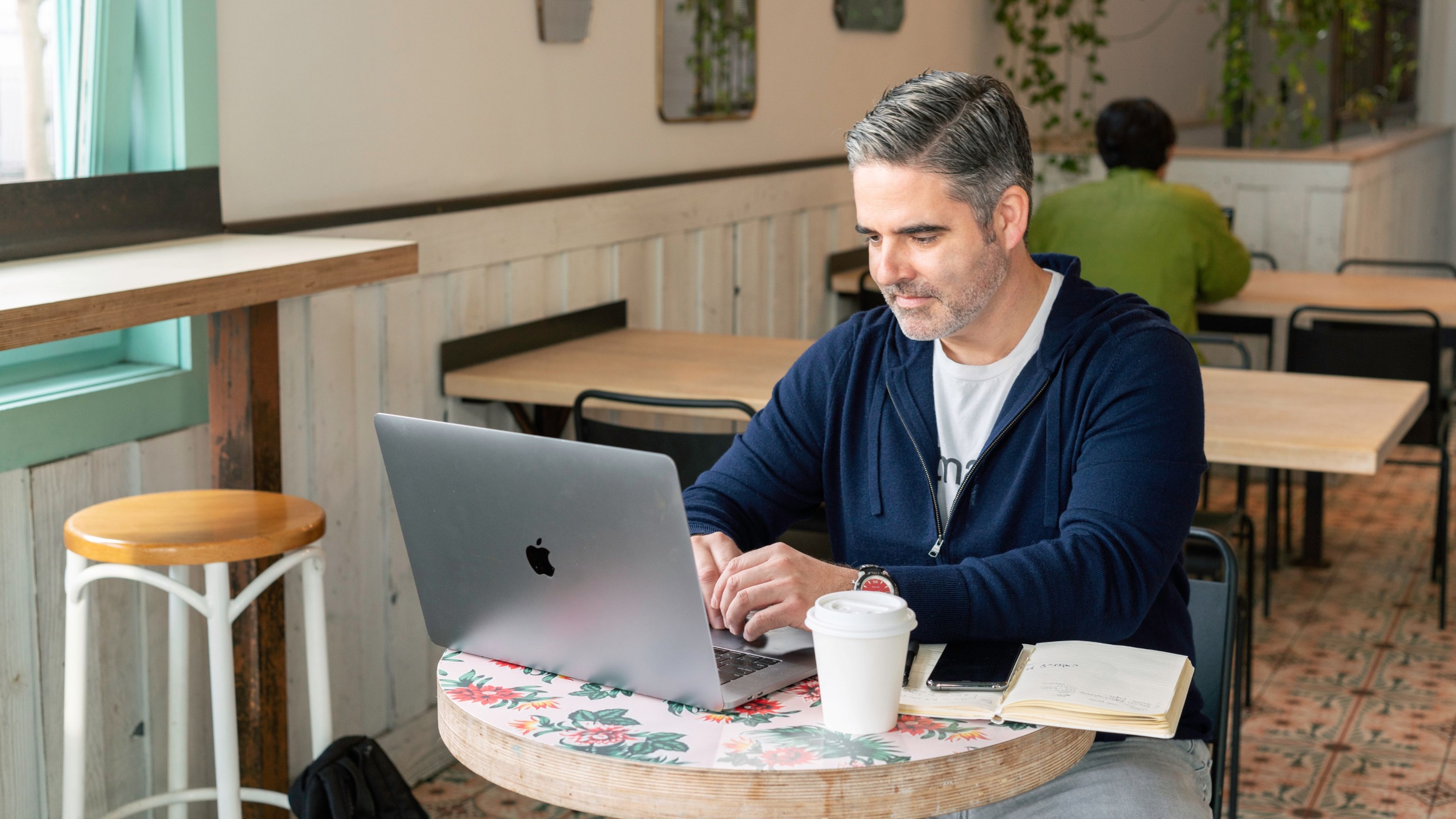 Hombre trabajando con un portátil en una cafetería