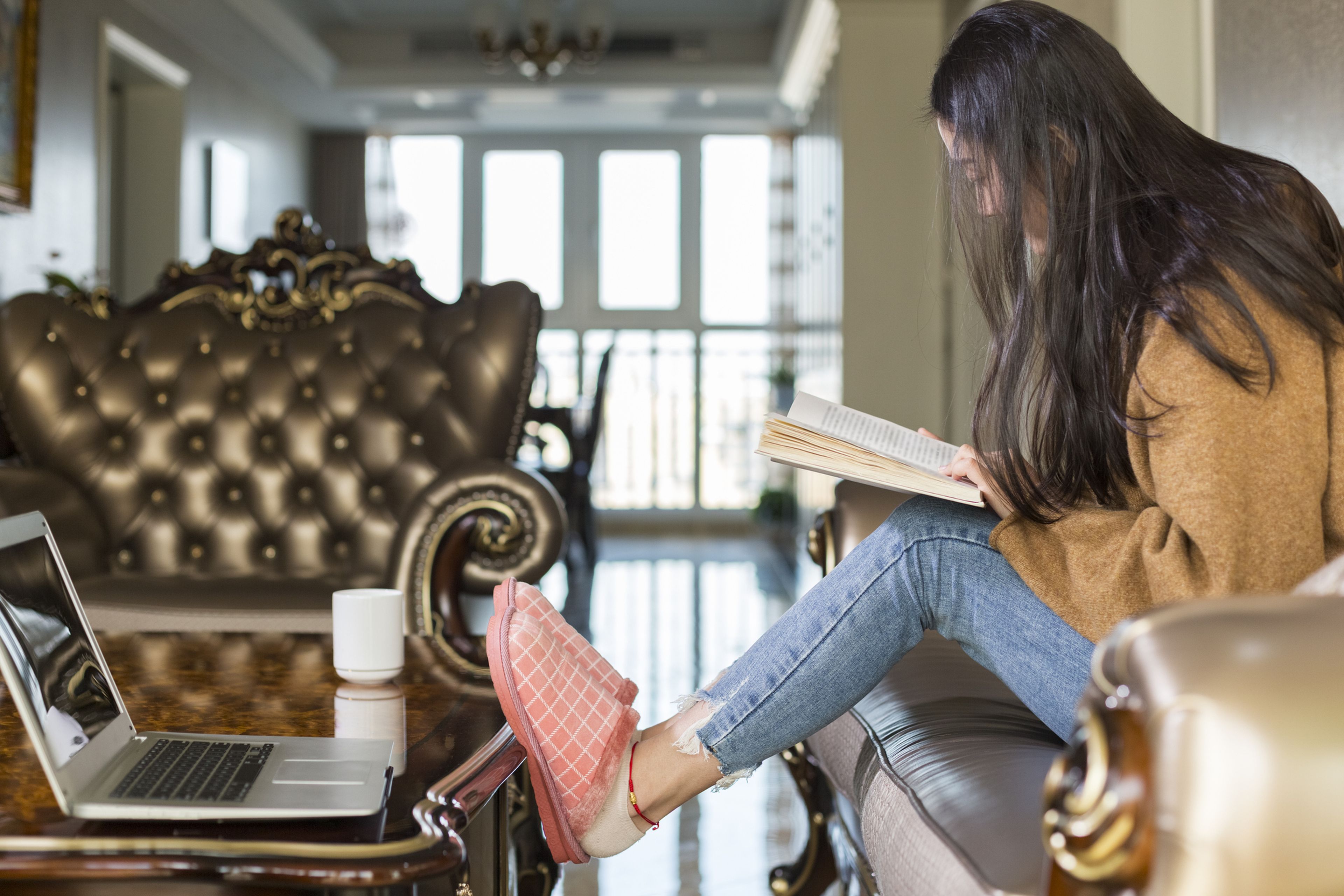 mujer con libro y zapatillas de casa leyendo, leer