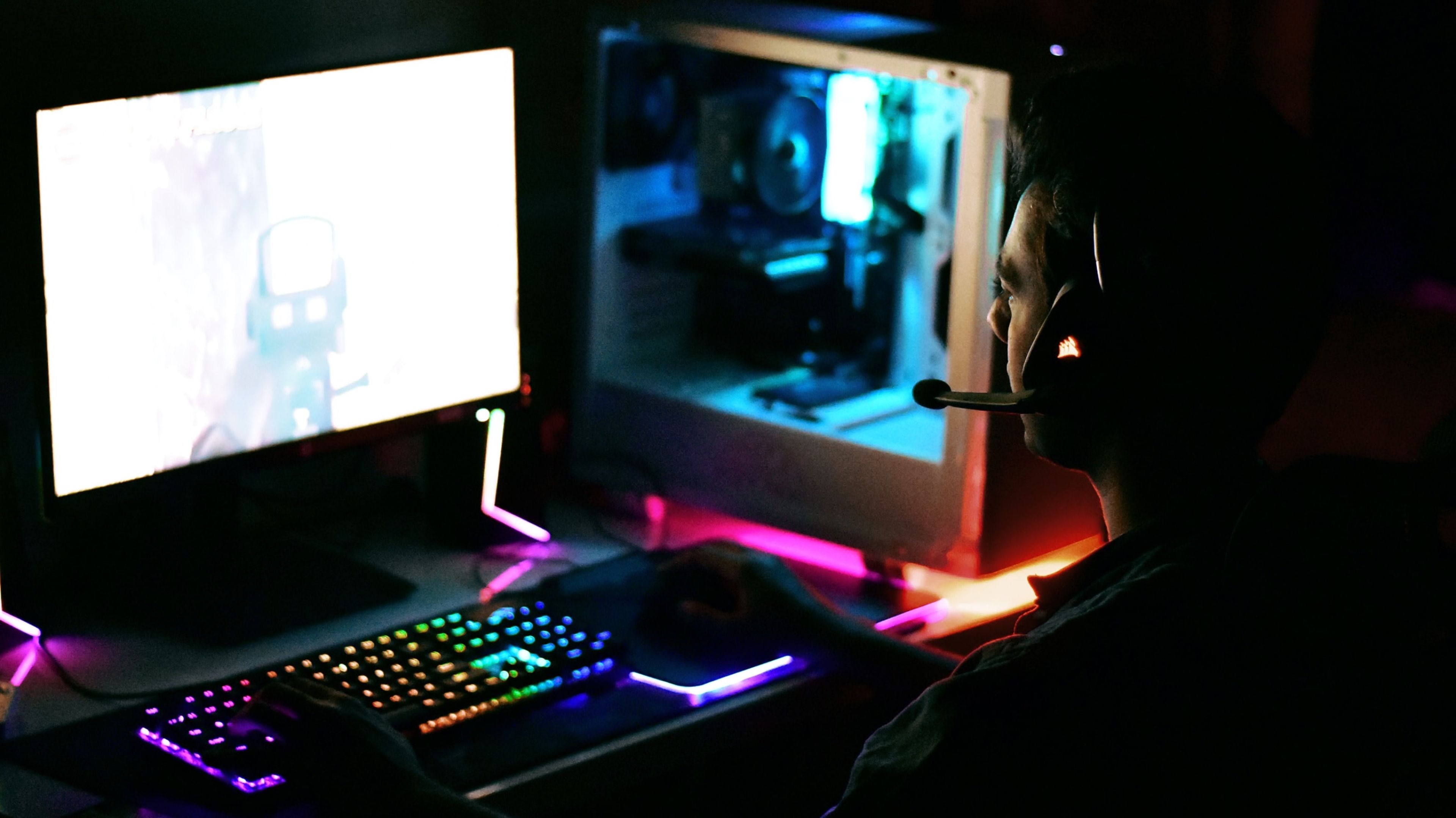Persona jugando en un PC Gaming con LEDs RGB y torre con cristal templado