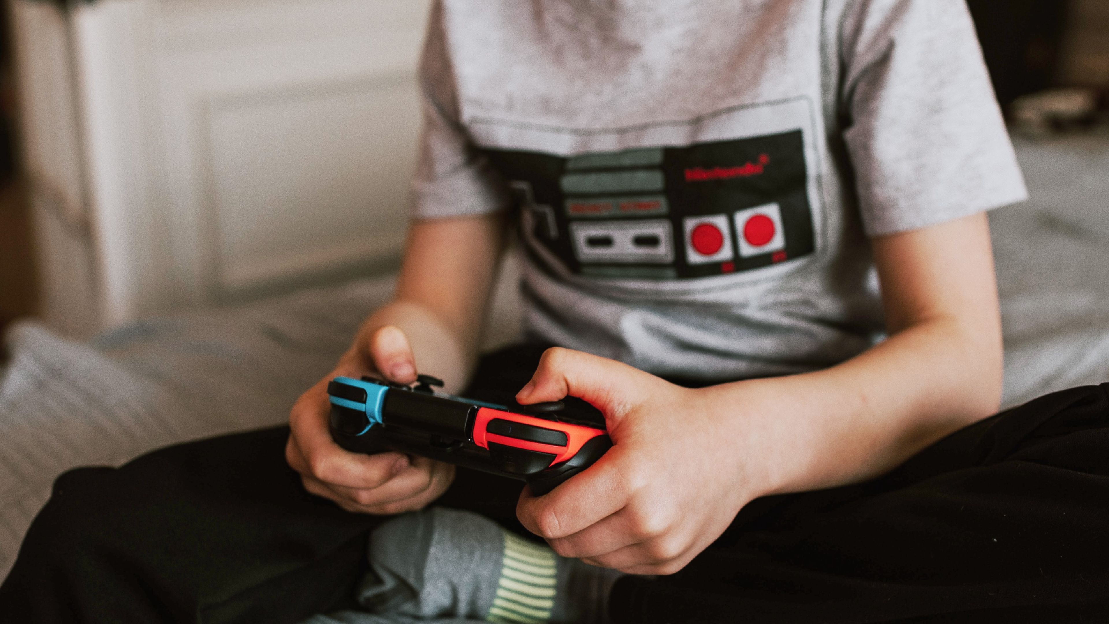 Niño jugando con una Nintendo Switch en una cama