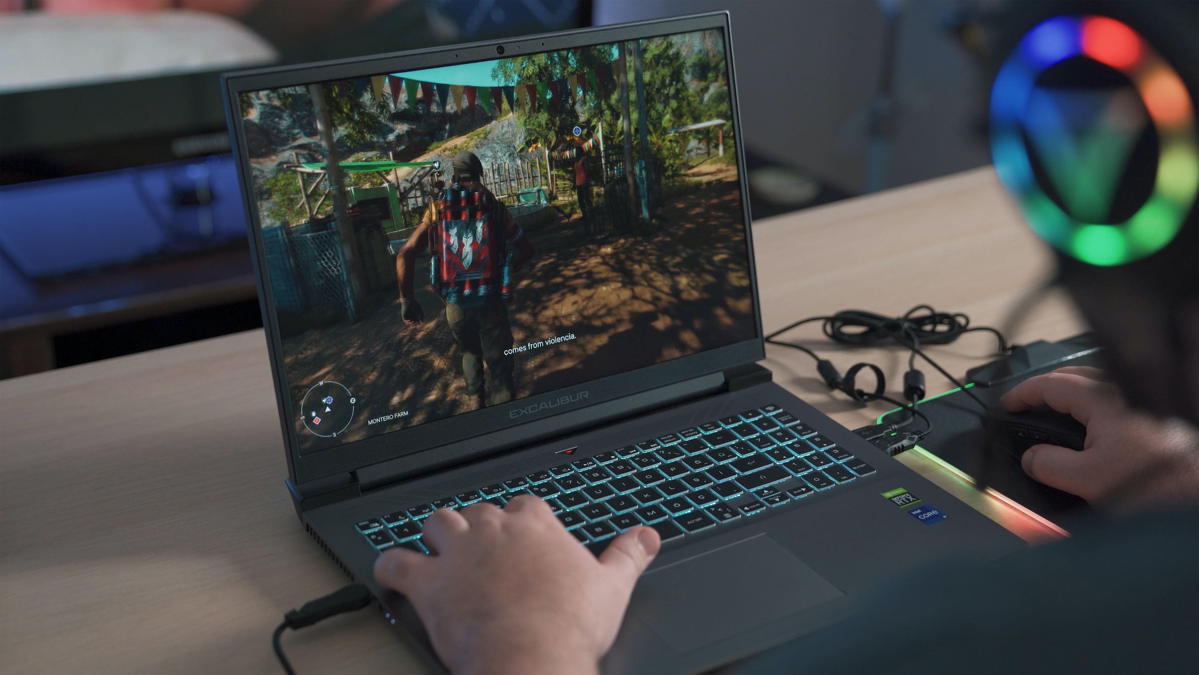 Persona jugando en un portátil gaming con auriculares con efectos de iluminación RGB