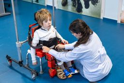 Un niño al que le están ajustando el exoesqueleto pediátrico adaptable