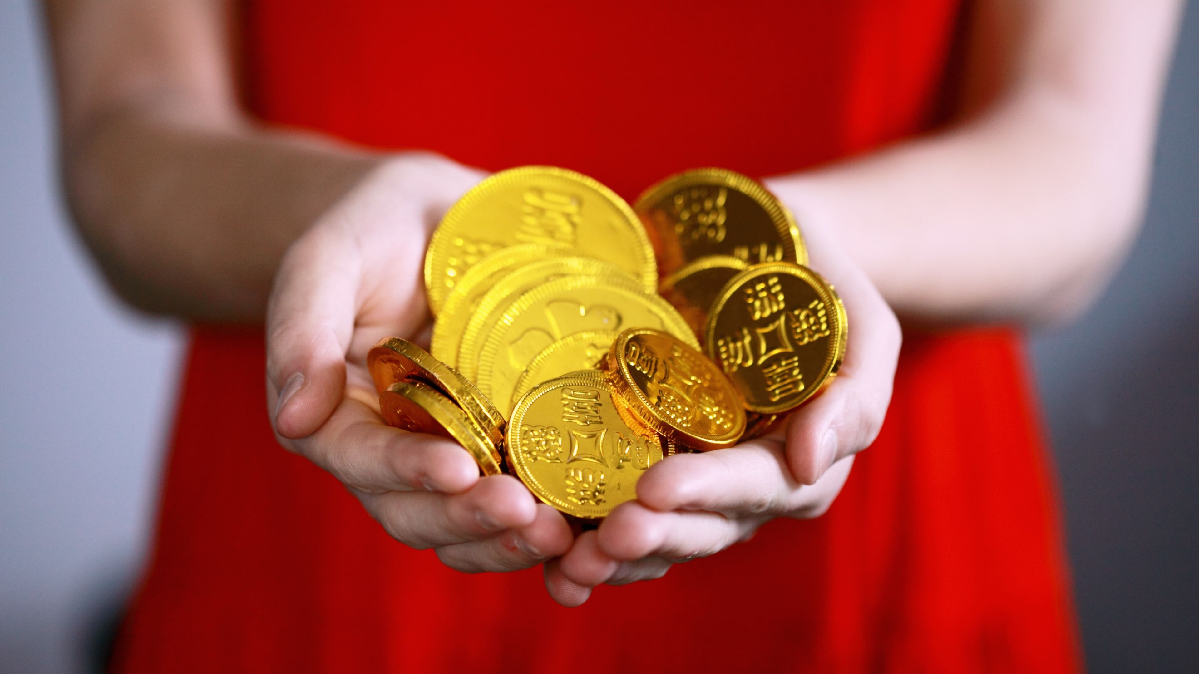 Persona sujetando monedas de oro en sus manos