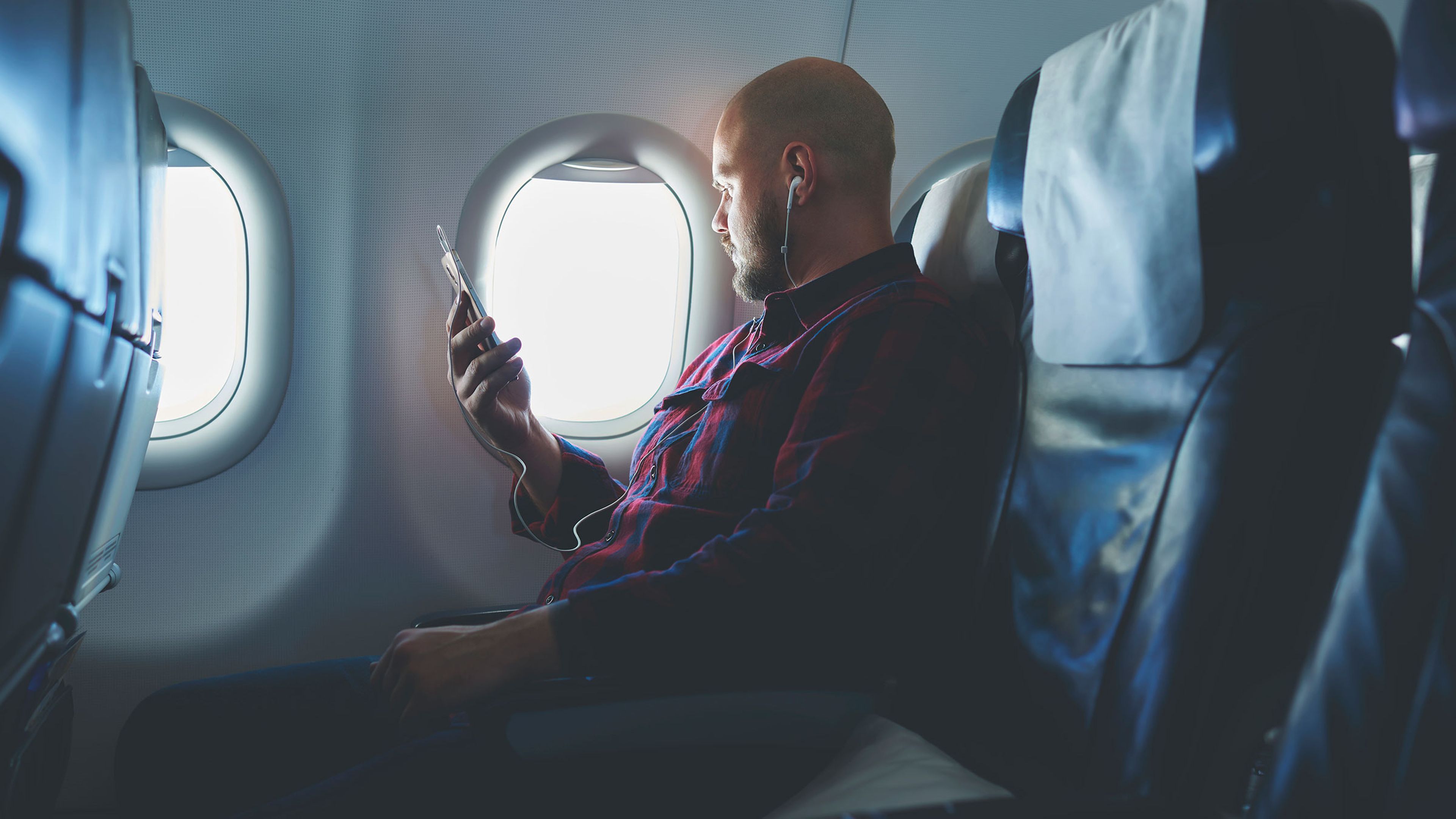 Hombre usando teléfono en un avión