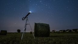 Telescopio en un campo de noche