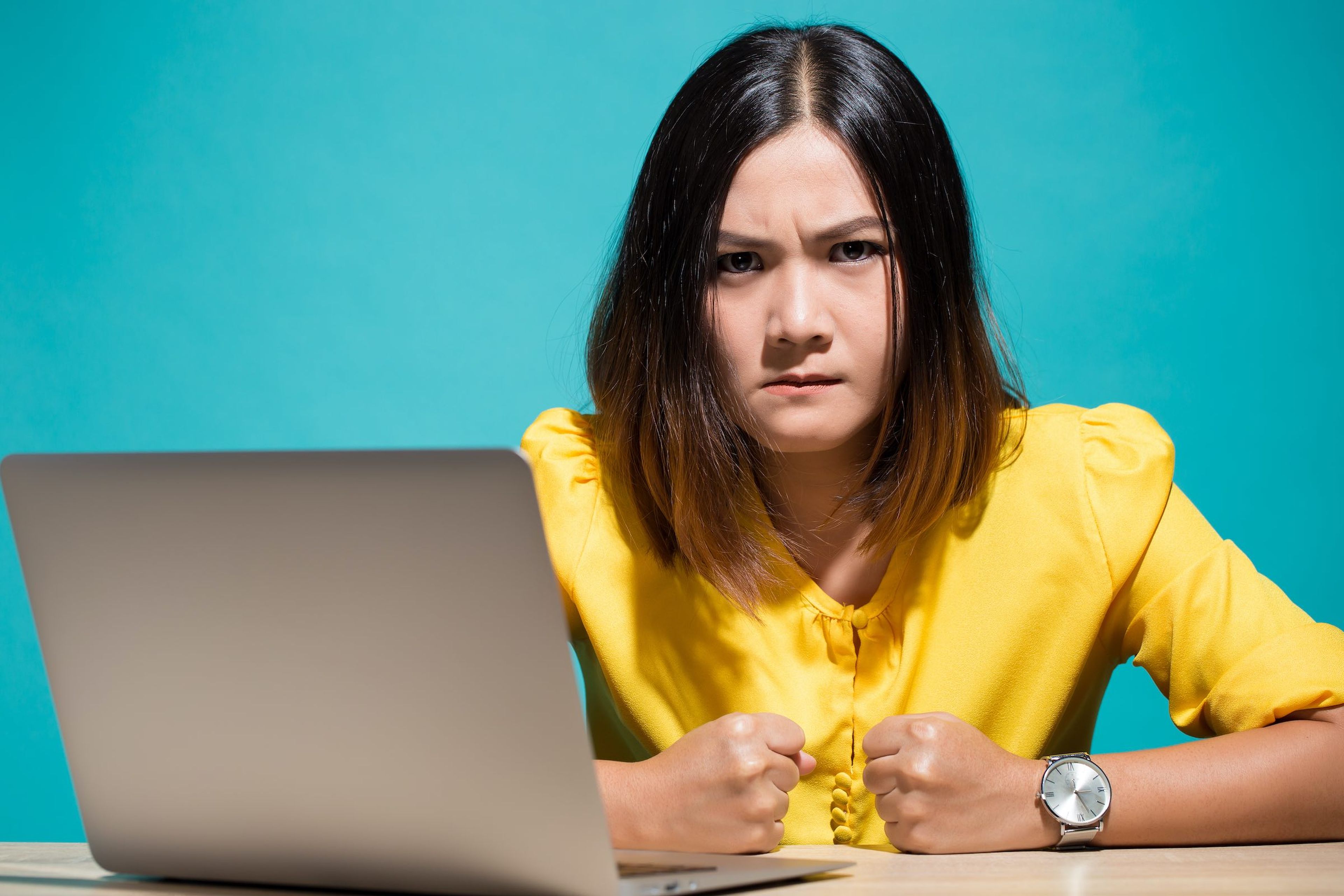 Mujer enfadada delante de un ordenador portátil