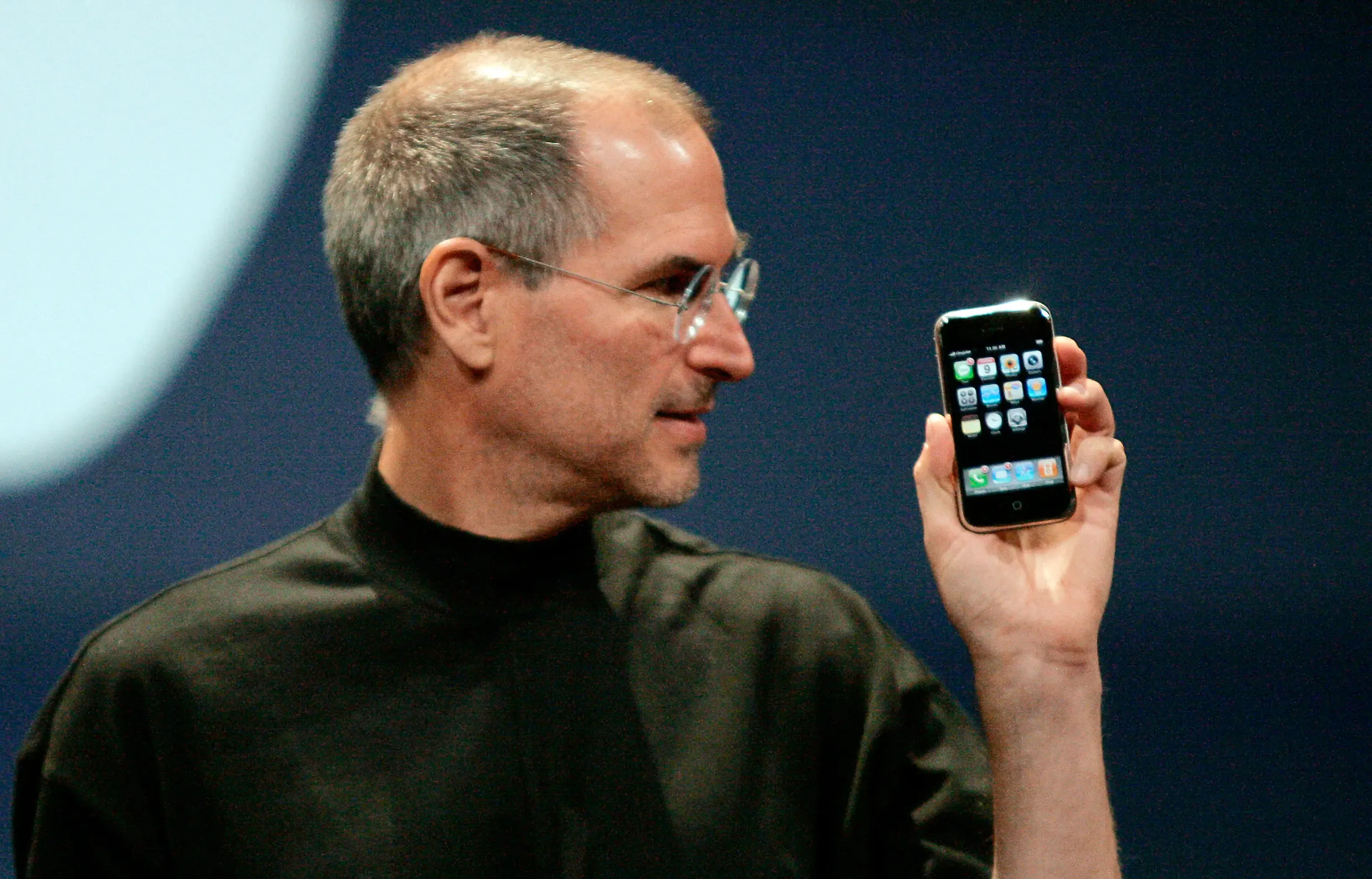Steve Jobs sosteniendo un iPhone