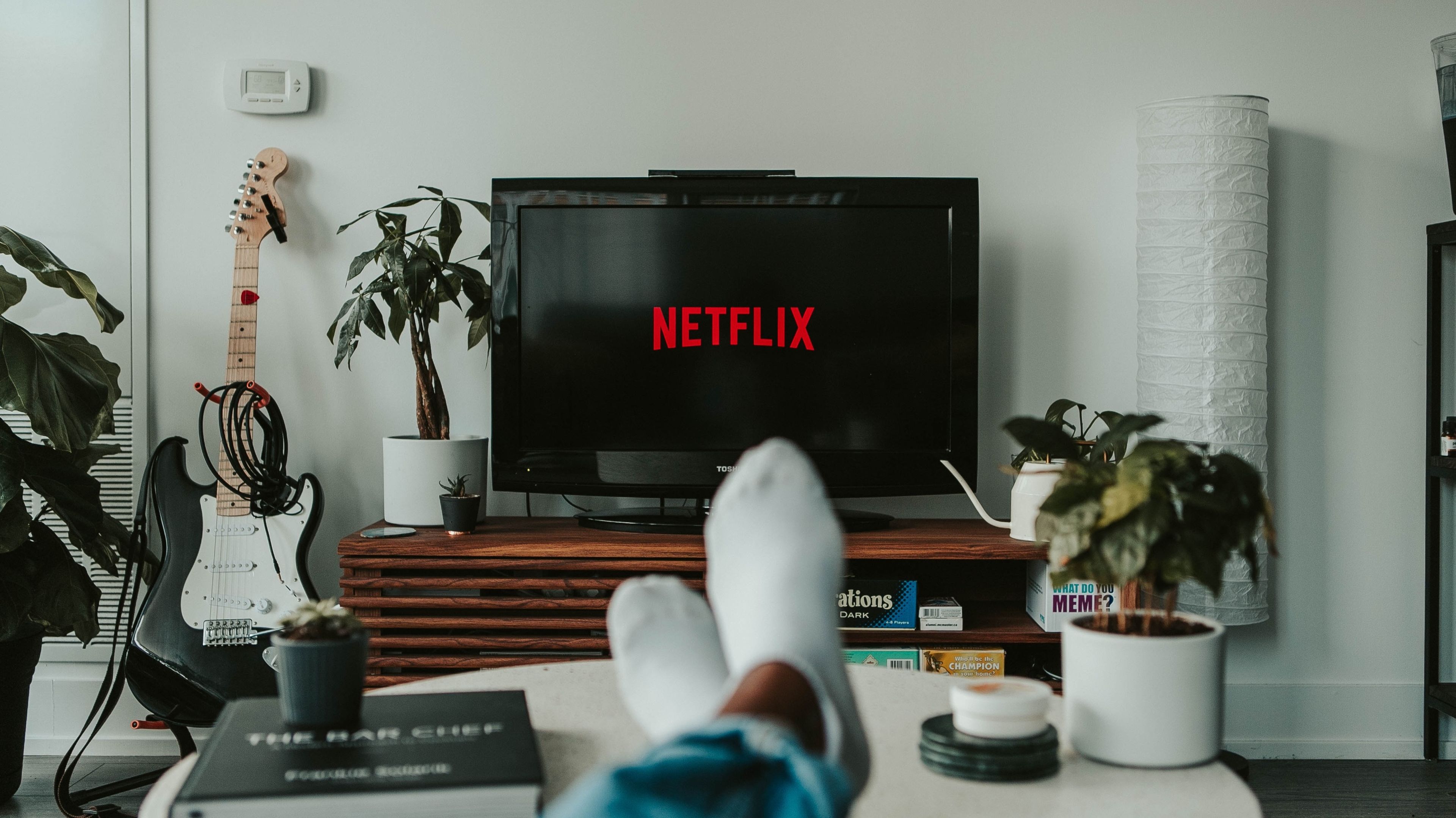 Smart TV con el logo de Netflix y una persona descansando con pies en alto