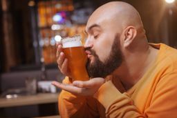 Hombre besando un vaso de cerveza