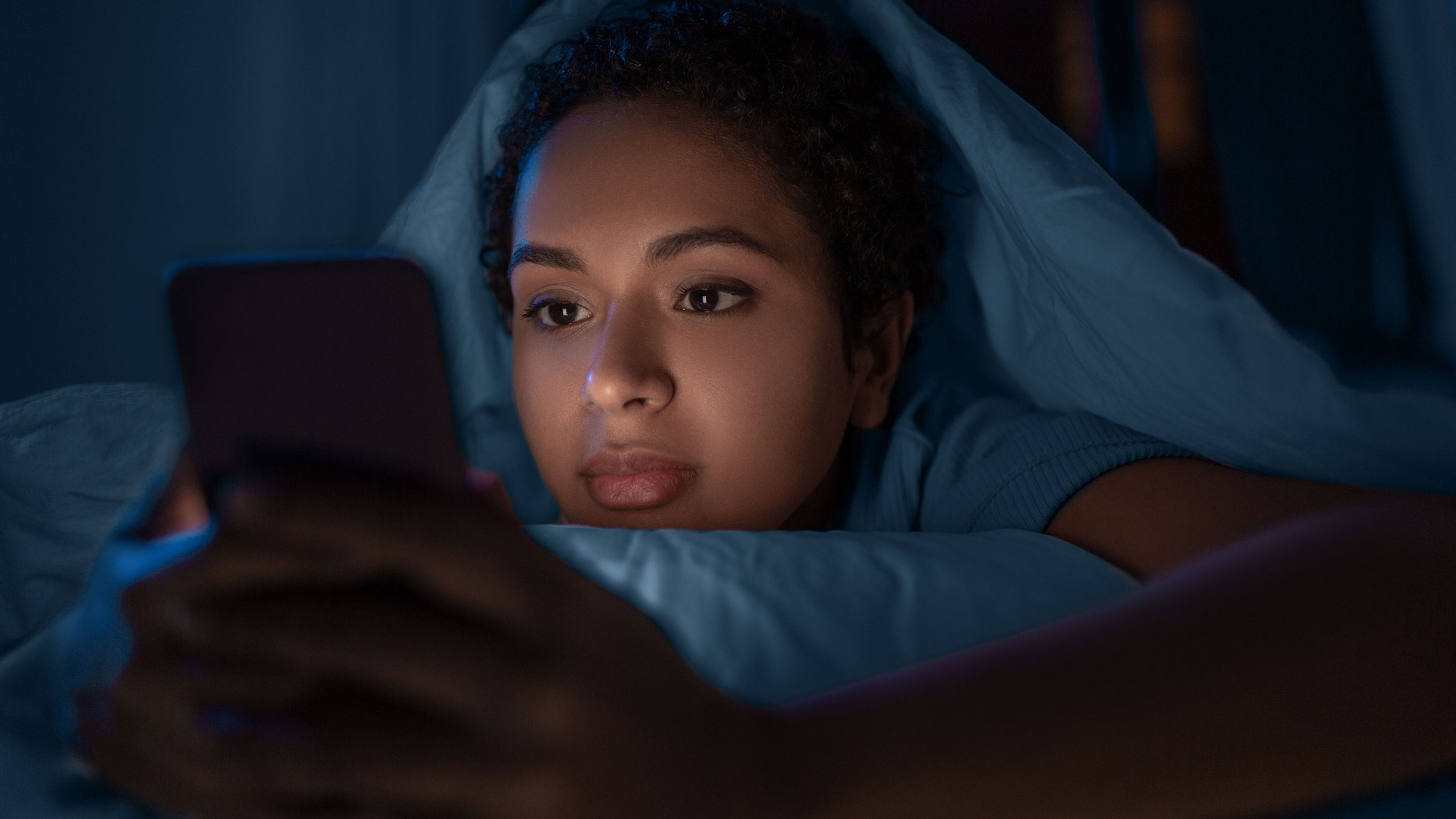 Mujer usa el móvil antes de irse a dormir