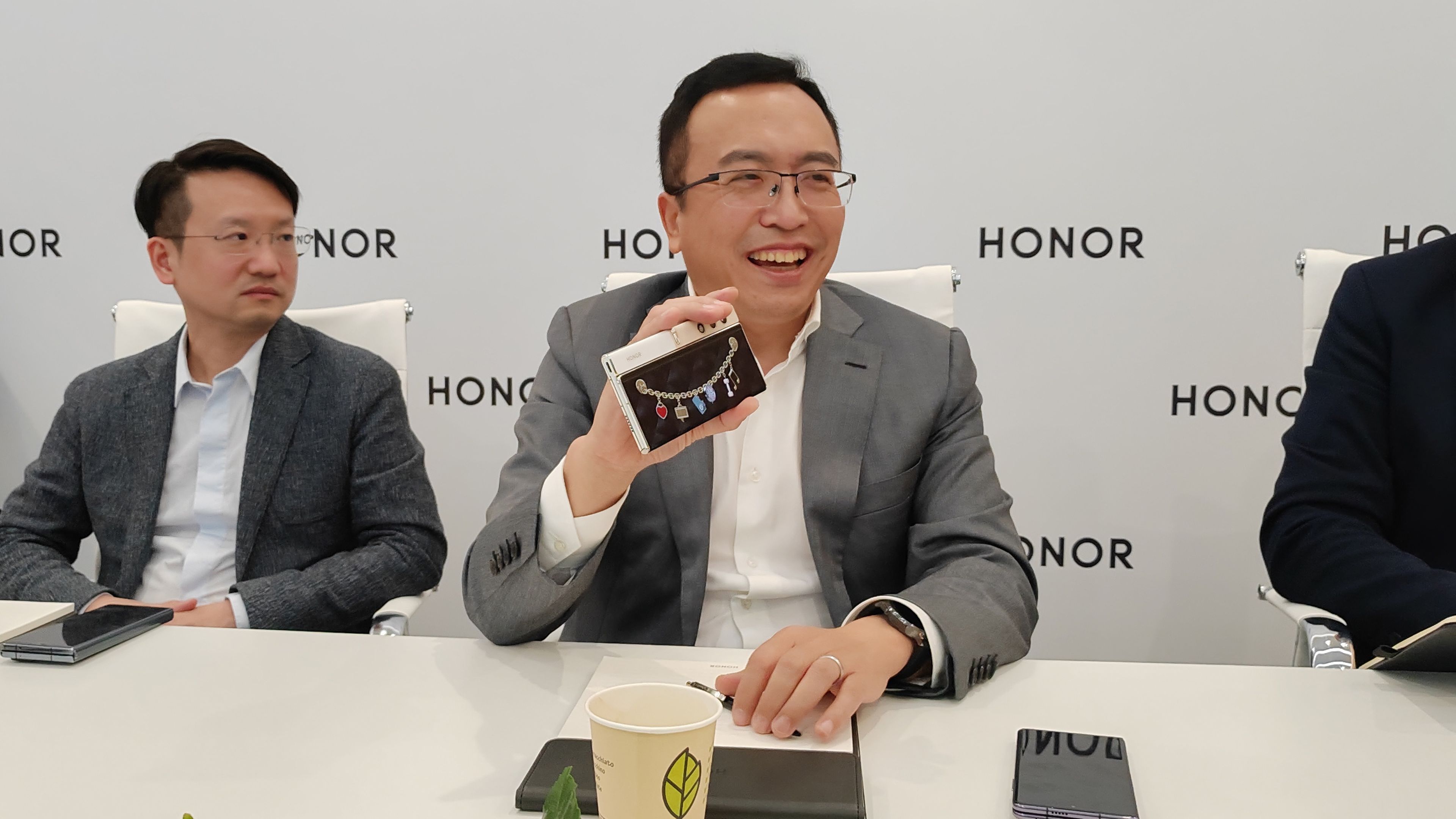 George Zhao (centro) mostrando Honor V Purse en una entrevista durante IFA 2023.