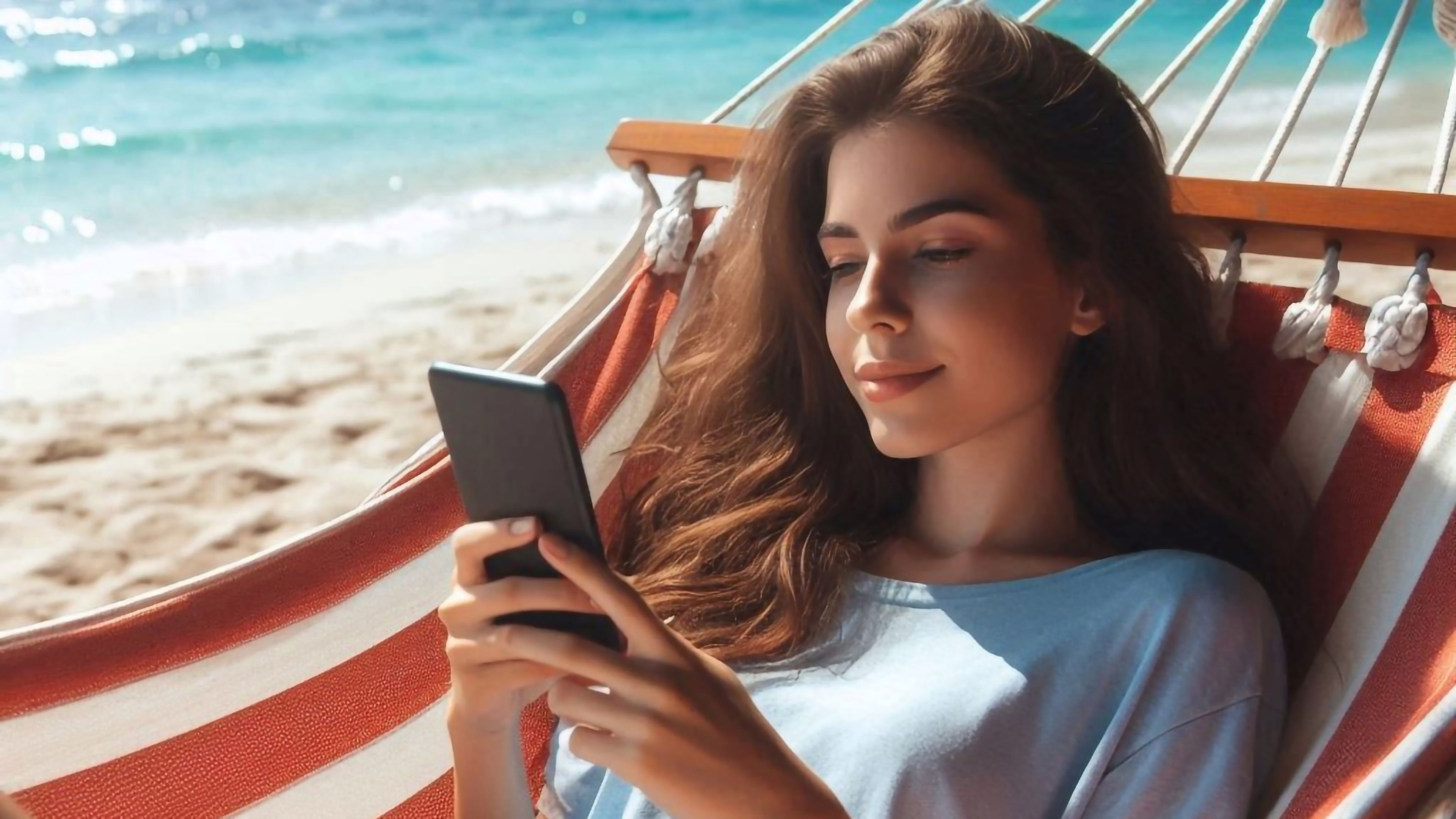 Chica mirando el móvil en la playa