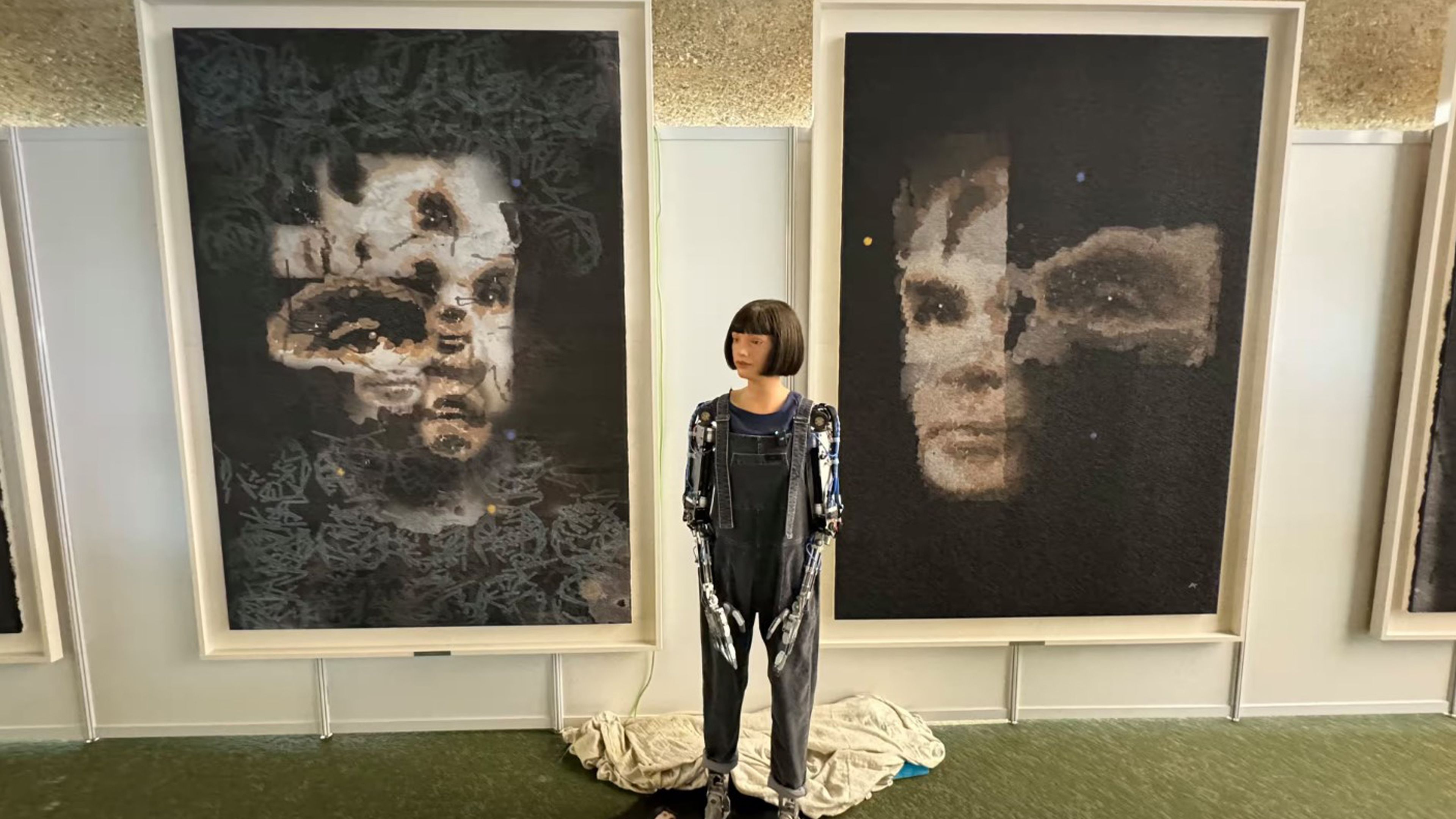 Ai-Da Robot, delante de sus retratos de Turing