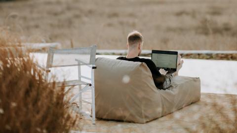 Hombre en una terraza trabajando con un portátil